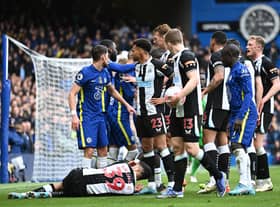 LONDON, ENGLAND - MARCH 13: Players of Chelsea and Newcastle United interact as Bruno Guimaraes of Newcastle United is injured during the Premier League match between Chelsea and Newcastle United at Stamford Bridge on March 13, 2022 in London, England. (Photo by Clive Mason/Getty Images)