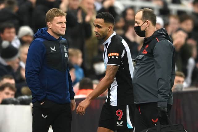 An injured Callum Wilson of Newcastle United leaves the field after picking up an injury as Newcastle boss Eddie Howe (l) looks on during the Premier League match between Newcastle United  and  Manchester United at St. James Park on December 27, 2021 in Newcastle upon Tyne, England. 