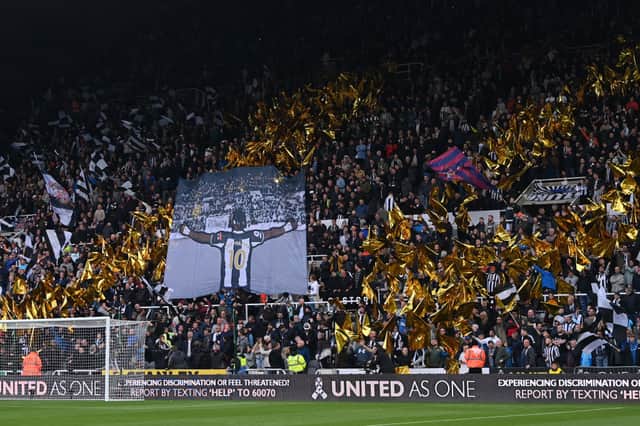 Fans of Newcastle United display flags in support of Allan Saint-Maximin of Newcastle United prior to the Premier League match between Newcastle United and Crystal Palace at St. James Park on April 20, 2022 in Newcastle upon Tyne, England. 