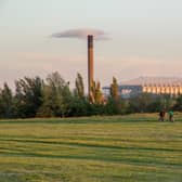 Friends cycle through Newcastle-Upon-Tyne’s Town Moor park with the impressive structure of St James Park football stadium looming large in the background.