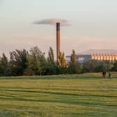 Friends cycle through Newcastle-Upon-Tyne’s Town Moor park with the impressive structure of St James Park football stadium looming large in the background.