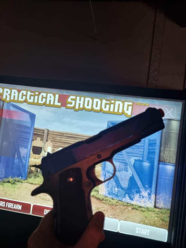 Replica guns are fired at a screen