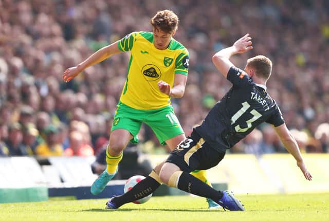 Kieran Dowell of Norwich City is challenged by Matt Targett of Newcastle United during the Premier League match between Norwich City and Newcastle United at Carrow Road on April 23, 2022 in Norwich, England.