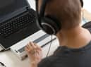 Global Accessibility Awareness Day focuses on digital access and inclusion for people with disabilities or impairments. (Image shows visually impaired person working on computer with assistive technology) 