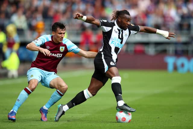 Allan Saint-Maximin of Newcastle United is challenged by Jack Cork of Burnley during the Premier League match between Burnley and Newcastle United at Turf Moor on May 22, 2022 in Burnley, England. 