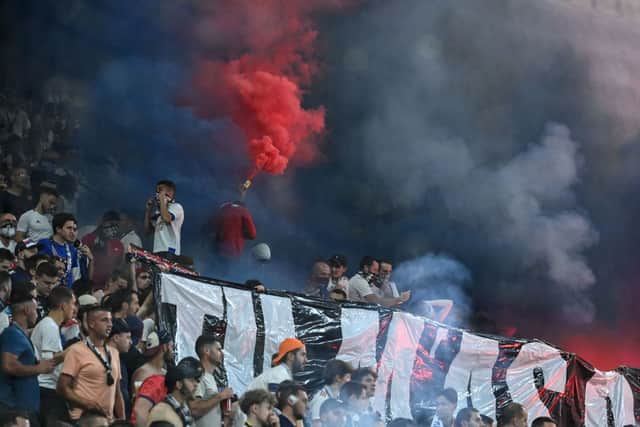 Supporters light a flare during the French L1 football match between Olympique Lyonnais (OL) and FC Nantes at The Groupama Stadium in Decines-Charpieu, central-eastern France on May 14, 2022.