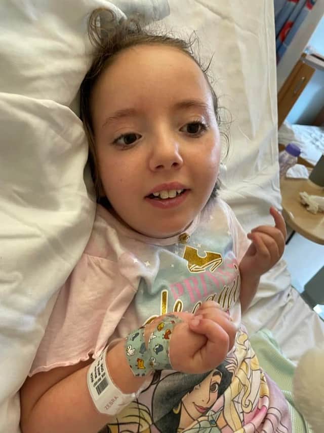 Nicole smiling through hospital treatment (Image -  Facebook: Nicole and Jessica’s Batten Journey)