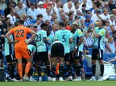 Newcastle United players take on water during a break in the Premier League match between Brighton & Hove Albion and Newcastle United at American Express Community Stadium on August 13, 2022 in Brighton, England.