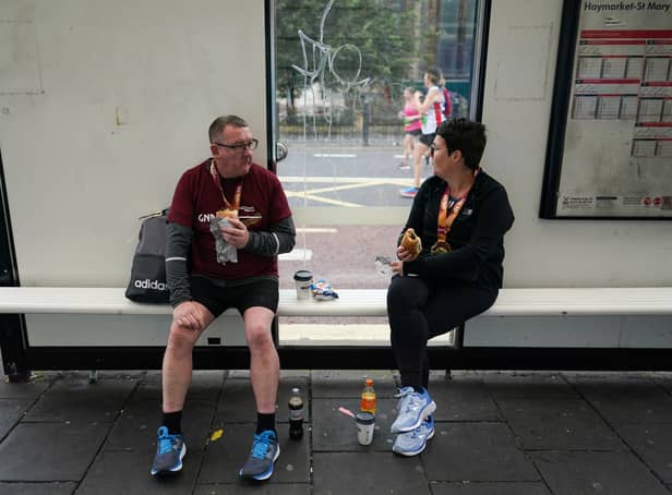 <p>Runners wait for the bus (Image: Getty Images)</p>