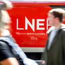 A passenger passes a London North Eastern Railway (LNER) train