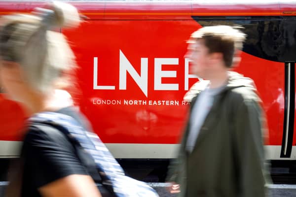 A passenger passes a London North Eastern Railway (LNER) train