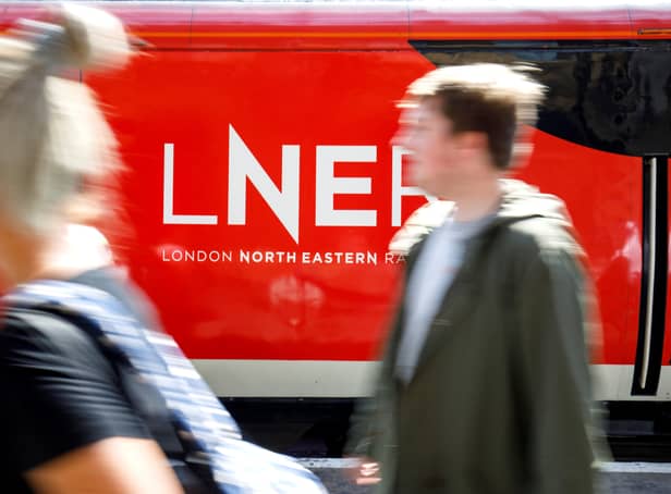 A passenger passes a London North Eastern Railway (LNER) train