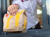 McDonald’s worker holds a bag of food at a Drive-Thru. 