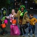 Children pose for a picture as they go trick-or-treating for Halloween in east London. 