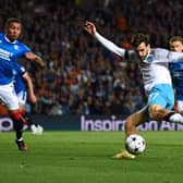 Napoli's Georgian forward Khvicha Kvaratskhelia (2nd R) kick the ball as Rangers' English defender James Tavernier (L) attemps to block it 