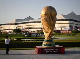 A man takes a picture of a FIFA World Cup trophy replica in front of the Al-Bayt Stadium in al-Khor on November 10, 2022, ahead of the Qatar 2022 FIFA World Cup football tournament. (Photo by Kirill KUDRYAVTSEV / AFP) (Photo by KIRILL KUDRYAVTSEV/AFP via Getty Images)