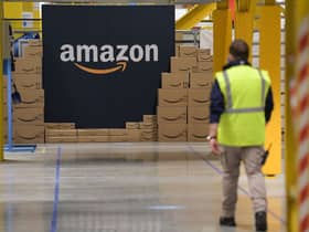 A US giant Amazon employee passes by its logo on the opening day of the new distribution center in Augny, eastern France, on September 23, 2021. (Photo by SEBASTIEN BOZON/AFP via Getty Images)