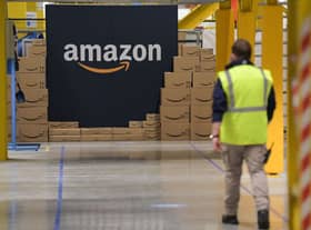 A US giant Amazon employee passes by its logo on the opening day of the new distribution center in Augny, eastern France, on September 23, 2021. (Photo by SEBASTIEN BOZON/AFP via Getty Images)