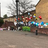Flowers and balloons are laid as a tribute to the teenager in Elswick