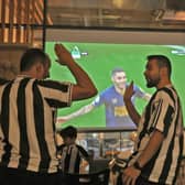Saudi fans of English football club Newcastle United celebrate a goal scored against Tottenham during as they watch the match at a cafe, in Riyadh on October 23, 2022. - The Saudi purchase of Newcastle - its sovereign wealth fund paid $408 million for an 80 percent stake - has proved deeply controversial, with critics quick to deride it as an example of “sportswashing”, or using athletics to distract from human rights abuses.The takeover was rubber-stamped by the Premier League only after it received legally binding assurances the Saudi state would not control the team. (Photo by Fayez Nureldine / AFP) (Photo by FAYEZ NURELDINE/AFP via Getty Images)