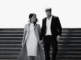 A black and white image of Meghan Markle and Prince Harry walking down a flight of stairs together, hand in hand and smiling (Credit: Netflix) 