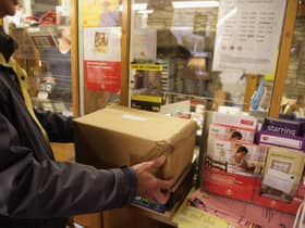 Customers weigh packages at the post office.