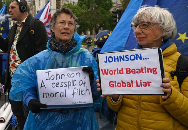 Demonstrators protest against Britain’s Prime Minister Boris Johnson, as he makes a statement in the House of Commons in London, on May 25, 2022 following the publication of the Sue Gray report