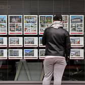 A member of the public looks at residential properties displayed for sale in the window of an estate agents' in London on September 30, 2022. (Photo by ISABEL INFANTES / AFP) (Photo by ISABEL INFANTES/AFP via Getty Images)