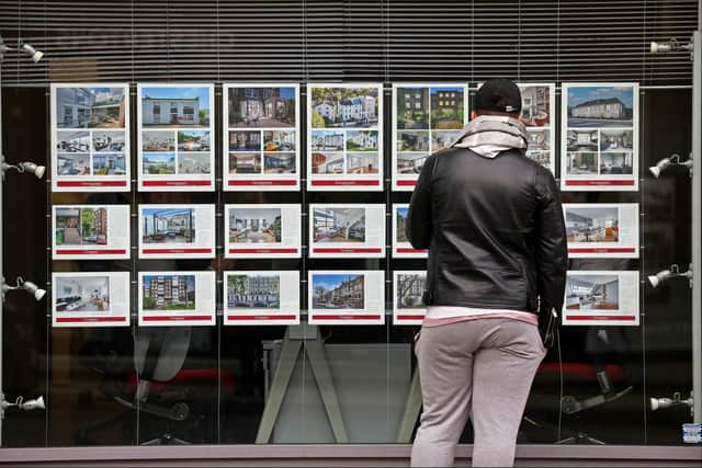 A member of the public looks at residential properties displayed for sale in the window of an estate agents' in London on September 30, 2022. (Photo by ISABEL INFANTES / AFP) (Photo by ISABEL INFANTES/AFP via Getty Images)