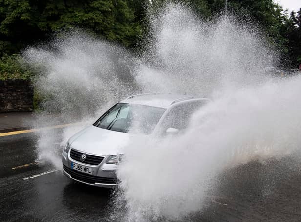 <p>A car drives through floodwater (Photo by Matthew Horwood/Getty Images)</p>