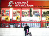 A woman waits outside a branch of Poundstretcher near Lewisham high street.