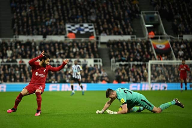 Liverpool's Egyptian striker Mohamed Salah (L) fights for the ball with Newcastle United's English goalkeeper Nick Pope (R) during the English Premier League football match between Newcastle United and Liverpool at St James' Park in Newcastle-upon-Tyne, north east England on February 18, 2023. - RESTRICTED TO EDITORIAL USE. No use with unauthorized audio, video, data, fixture lists, club/league logos or 'live' services. Online in-match use limited to 120 images. An additional 40 images may be used in extra time. No video emulation. Social media in-match use limited to 120 images. An additional 40 images may be used in extra time. No use in betting publications, games or single club/league/player publications. (Photo by Oli SCARFF / AFP) / RESTRICTED TO EDITORIAL USE. No use with unauthorized audio, video, data, fixture lists, club/league logos or 'live' services. Online in-match use limited to 120 images. An additional 40 images may be used in extra time. No video emulation. Social media in-match use limited to 120 images. An additional 40 images may be used in extra time. No use in betting publications, games or single club/league/player publications. / RESTRICTED TO EDITORIAL USE. No use with unauthorized audio, video, data, fixture lists, club/league logos or 'live' services. Online in-match use limited to 120 images. An additional 40 images may be used in extra time. No video emulation. Social media in-match use limited to 120 images. An additional 40 images may be used in extra time. No use in betting publications, games or single club/league/player publications. (Photo by OLI SCARFF/AFP via Getty Images)