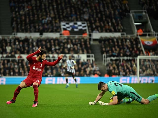 Liverpool's Egyptian striker Mohamed Salah (L) fights for the ball with Newcastle United's English goalkeeper Nick Pope (R) during the English Premier League football match between Newcastle United and Liverpool at St James' Park in Newcastle-upon-Tyne, north east England on February 18, 2023. - RESTRICTED TO EDITORIAL USE. No use with unauthorized audio, video, data, fixture lists, club/league logos or 'live' services. Online in-match use limited to 120 images. An additional 40 images may be used in extra time. No video emulation. Social media in-match use limited to 120 images. An additional 40 images may be used in extra time. No use in betting publications, games or single club/league/player publications. (Photo by Oli SCARFF / AFP) / RESTRICTED TO EDITORIAL USE. No use with unauthorized audio, video, data, fixture lists, club/league logos or 'live' services. Online in-match use limited to 120 images. An additional 40 images may be used in extra time. No video emulation. Social media in-match use limited to 120 images. An additional 40 images may be used in extra time. No use in betting publications, games or single club/league/player publications. / RESTRICTED TO EDITORIAL USE. No use with unauthorized audio, video, data, fixture lists, club/league logos or 'live' services. Online in-match use limited to 120 images. An additional 40 images may be used in extra time. No video emulation. Social media in-match use limited to 120 images. An additional 40 images may be used in extra time. No use in betting publications, games or single club/league/player publications. (Photo by OLI SCARFF/AFP via Getty Images)