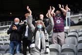 A Newcastle fan  wearing a face covering applauds the players as they enter the field during the Premier League match between Newcastle United and Sheffield United at St. James Park on May 19, 2021.