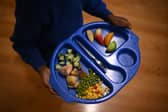A child carries a tray with food during lunch-break at St Mary’s RC Primary School, in Battersea, south London.