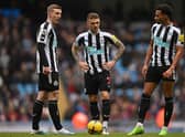 (L-R) Newcastle United's English defender Matt Targett, Newcastle United's English defender Kieran Trippier and Newcastle United's English midfielder Jacob Murphy discuss the taking of a free-kick during the English Premier League football match between Manchester City and Newcastle United at the Etihad Stadium in Manchester, north west England, on March 4, 2023. (Photo by Paul ELLIS / AFP) 