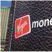 British entrepreneur Richard Branson walks out of a giant wallet as he launches Virgin Money's new credit cards in Sydney Harbour on July 27, 2010. The financial services arm of Branson's Virgin Group now offers Australians low interest rate credit cards, savings accounts, superannuation and car insurance. AFP PHOTO / Torsten BLACKWOOD (Photo by TORSTEN BLACKWOOD / AFP) (Photo by TORSTEN BLACKWOOD/AFP via Getty Images)
