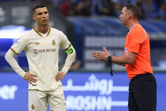 Cristiano Ronaldo (L) listens to the English referee Michael Oliver (R) during the Saudi Pro League football match between Al-Hilal and Al-Nassr at the Prince Faisal Bin Fahd stadium in the capital Riyadh on April 18, 2023. (Photo by Fayez Nureldine / AFP)