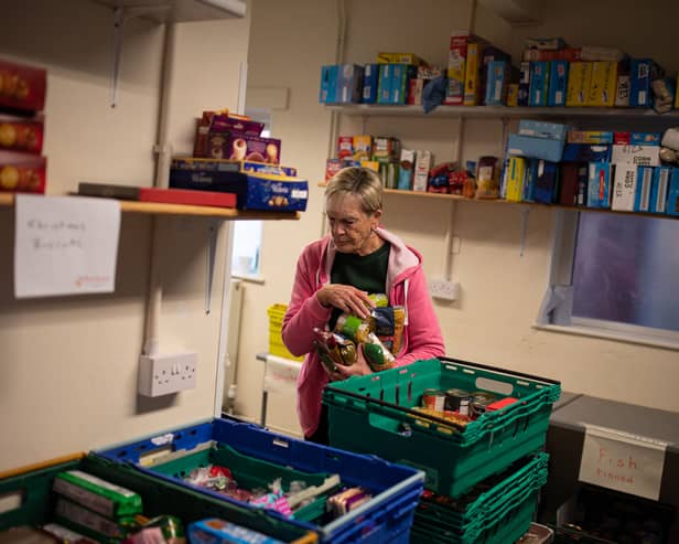 A worker at the Coventry Foodbank centre in Queens Road Baptist Church collates donated food items into parcels that will be provided to people arriving with a foodbank voucher.