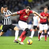 Phil Jones of Manchester United is challenged by Ayoze Perez of Newcastle United during the Premier League match between Newcastle United and Manchester United at St. James Park on January 2, 2019.