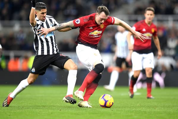 Phil Jones of Manchester United is challenged by Ayoze Perez of Newcastle United during the Premier League match between Newcastle United and Manchester United at St. James Park on January 2, 2019.