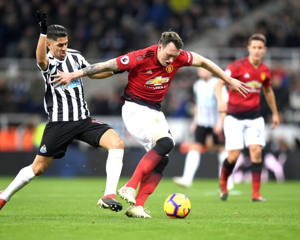 Phil Jones of Manchester United is challenged by Ayoze Perez of Newcastle United during the Premier League match between Newcastle United and Manchester United at St. James Park on January 2, 2019.