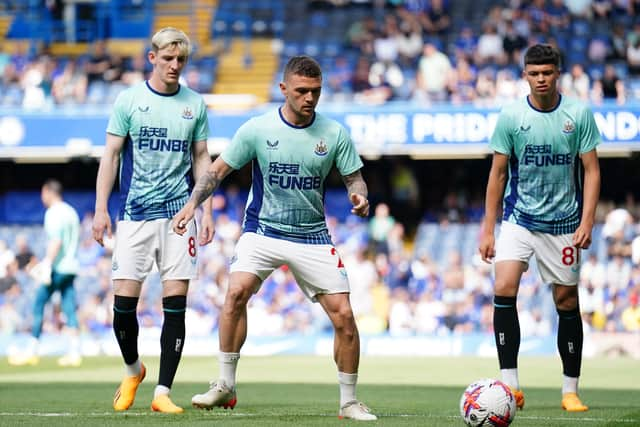 Anthony Gordon, Kieran Trippier and Lewis Miley warm up at Stamford Bridge.