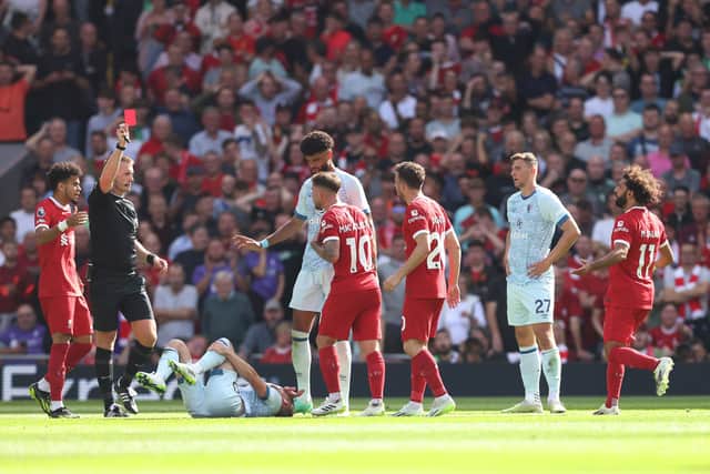  Referee Thomas Bramall shows a red card to Alexis Mac Allister of Liverpool following a challenge on Ryan Christie of AFC Bournemouth (on floor) during the Premier League match between Liverpool FC and AFC Bournemouth at Anfield on August 19, 2023 in Liverpool, England. (Photo by George Wood/Getty Images)