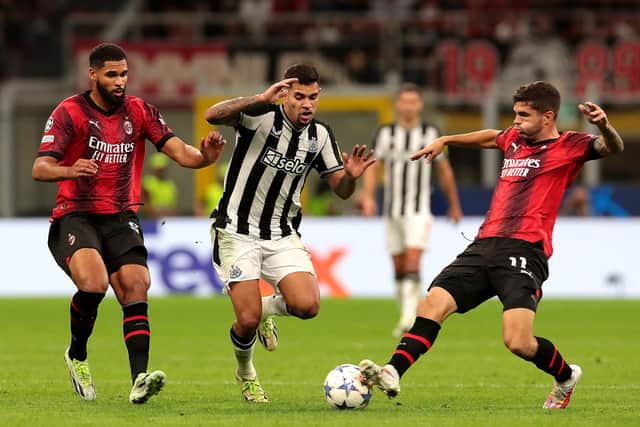 Bruno Guimaraes of Newcastle United challenges for the ball with Olivier Giroud and Christian Pulisic of AC Milan during the UEFA Champions League Group F match between AC Milan and Newcastle United FC at Stadio Giuseppe Meazza on September 19, 2023 in Milan, Italy.