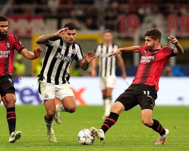 Bruno Guimaraes of Newcastle United challenges for the ball with Olivier Giroud and Christian Pulisic of AC Milan during the UEFA Champions League Group F match between AC Milan and Newcastle United FC at Stadio Giuseppe Meazza on September 19, 2023 in Milan, Italy. 