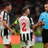 Fabian Schar and Kieran Trippier of Newcastle United interact with Referee Jose Maria Sanchez Martinez during the UEFA Champions League Group F match between AC Milan and Newcastle United FC at Stadio Giuseppe Meazza on September 19, 2023 in Milan, Italy. (Photo by Emilio Andreoli/Getty Images)