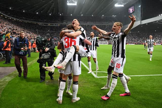 Sean Longstaff of Newcastle United celebrates with Miguel Almiron of Newcastle United after scoring the team’s third goal during the UEFA Champions League match between Newcastle United FC and Paris Saint-Germain at St. James Park on October 04, 2023 in Newcastle upon Tyne, England.
