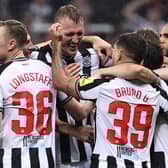Newcastle United's English defender #33 Dan Burn (2L) is mobbed by teammates after scoring the team's second goal during the UEFA Champions League Group F football match between Newcastle United and Paris Saint-Germain at St James' Park in Newcastle-upon-Tyne, north east England on October 4, 2023. (Photo by FRANCK FIFE / AFP) 