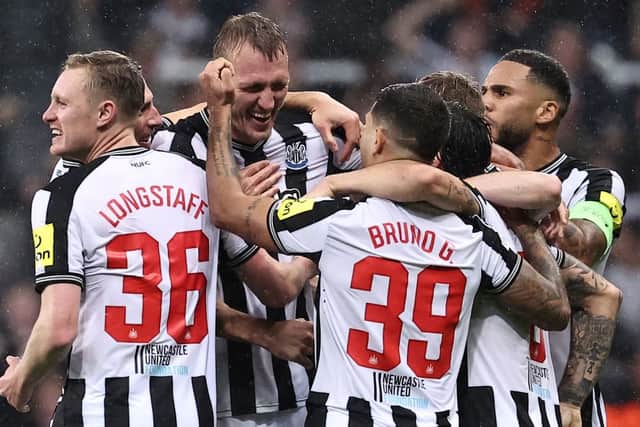 Newcastle United's English defender #33 Dan Burn (2L) is mobbed by teammates after scoring the team's second goal during the UEFA Champions League Group F football match between Newcastle United and Paris Saint-Germain at St James' Park in Newcastle-upon-Tyne, north east England on October 4, 2023. (Photo by FRANCK FIFE / AFP)